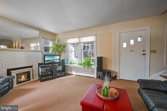 living room with radiator, a fireplace, and carpet flooring