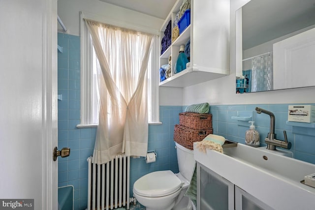 bathroom featuring radiator heating unit, toilet, sink, and tile walls