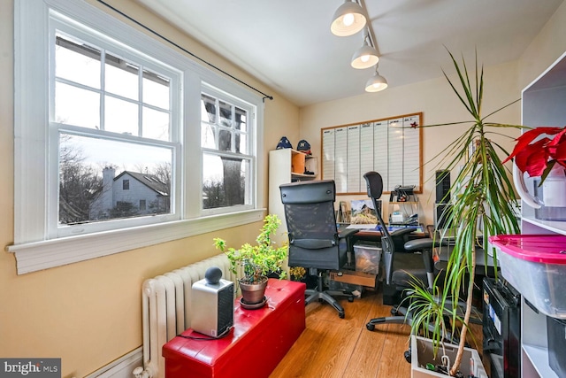 office area with radiator and hardwood / wood-style floors