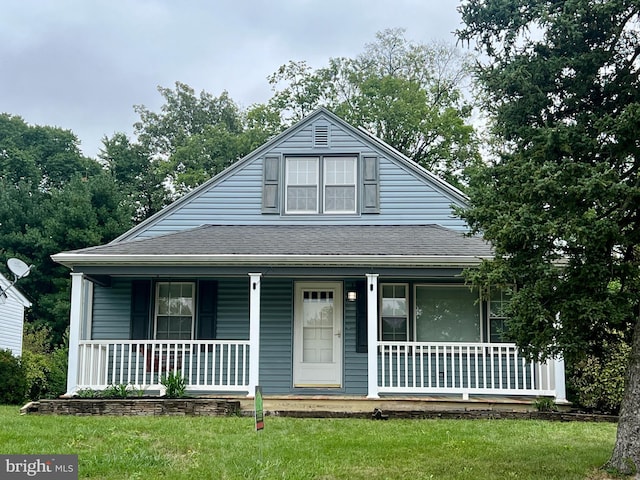 view of front of property featuring covered porch and a front yard