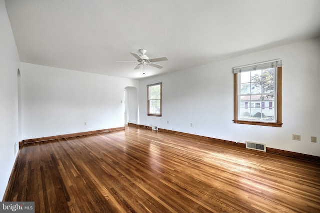 empty room featuring wood-type flooring, ceiling fan, and a wealth of natural light