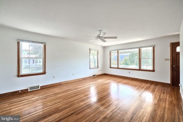 unfurnished room featuring plenty of natural light, wood-type flooring, and ceiling fan