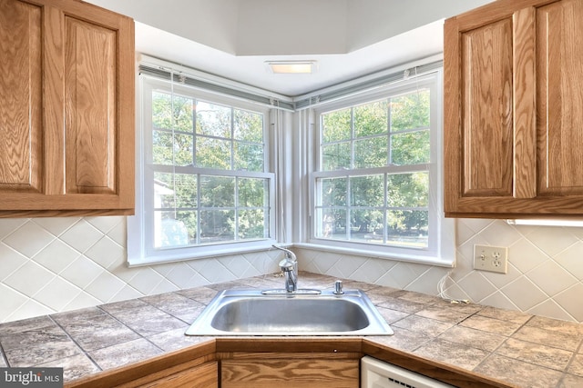 kitchen featuring tile countertops, decorative backsplash, and sink