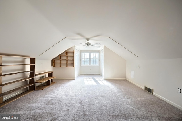 additional living space featuring ceiling fan, built in shelves, carpet floors, and vaulted ceiling