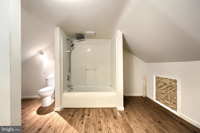 bathroom featuring hardwood / wood-style floors, vaulted ceiling, bathtub / shower combination, and toilet