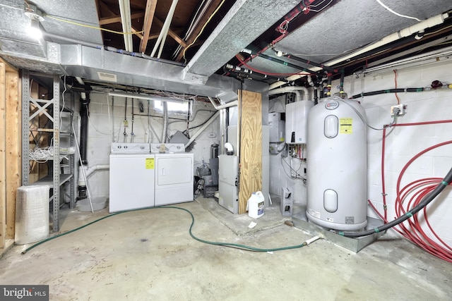 basement featuring electric water heater and washing machine and clothes dryer