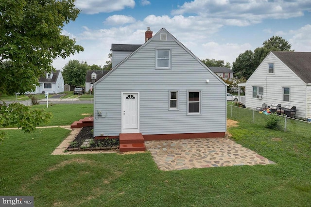 rear view of house with a lawn and a patio