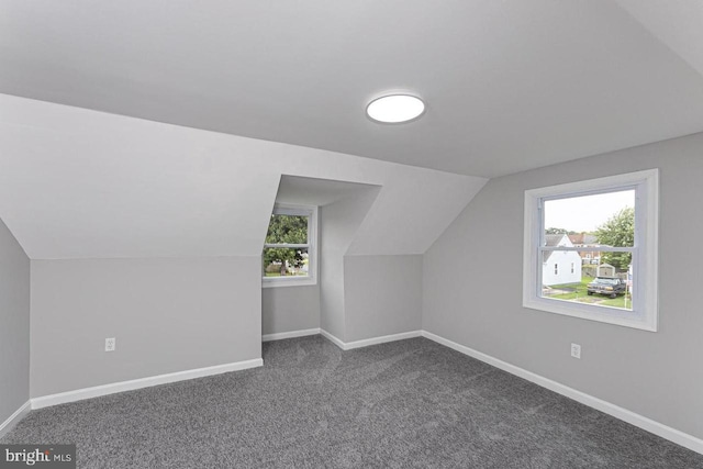 bonus room featuring lofted ceiling, plenty of natural light, and carpet flooring