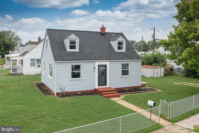 cape cod-style house with a storage unit and a front lawn