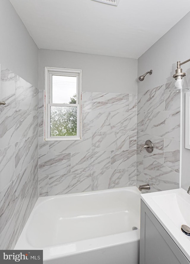 bathroom featuring vanity and tiled shower / bath combo