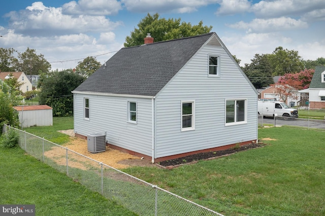 view of side of home with central AC, a lawn, and a storage unit