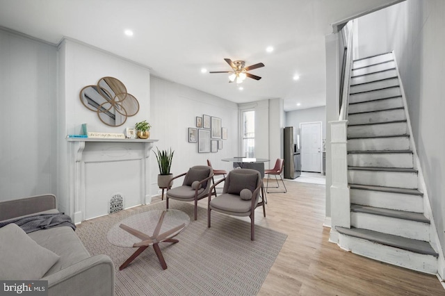 living room with light wood-type flooring and ceiling fan