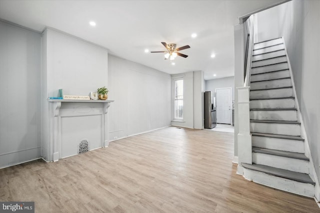 unfurnished living room featuring ceiling fan and light hardwood / wood-style floors