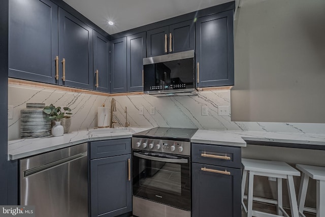 kitchen with appliances with stainless steel finishes, backsplash, and light stone counters