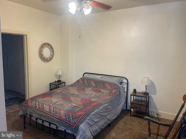 bedroom with dark colored carpet and ceiling fan