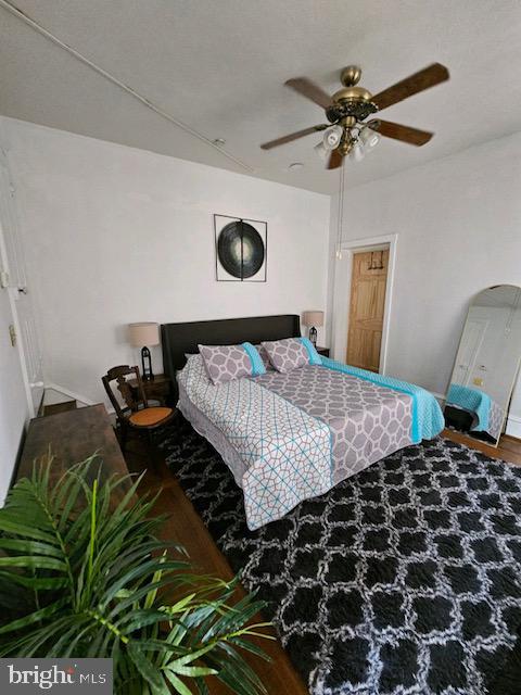 bedroom with wood-type flooring and ceiling fan