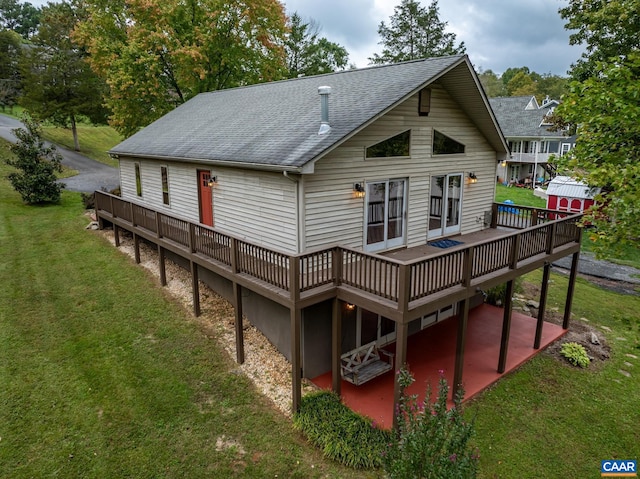 rear view of house featuring a wooden deck and a yard