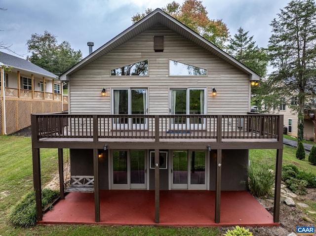 rear view of house featuring a patio area, a deck, and a lawn