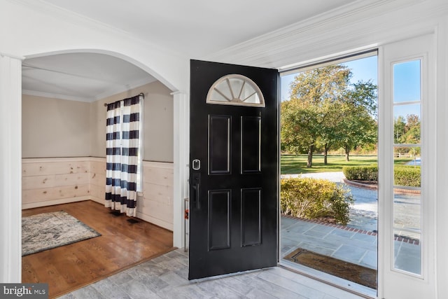 entryway with crown molding and wood-type flooring