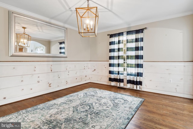 spare room with crown molding, hardwood / wood-style flooring, and a chandelier