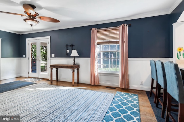 foyer with french doors, ornamental molding, hardwood / wood-style floors, and plenty of natural light