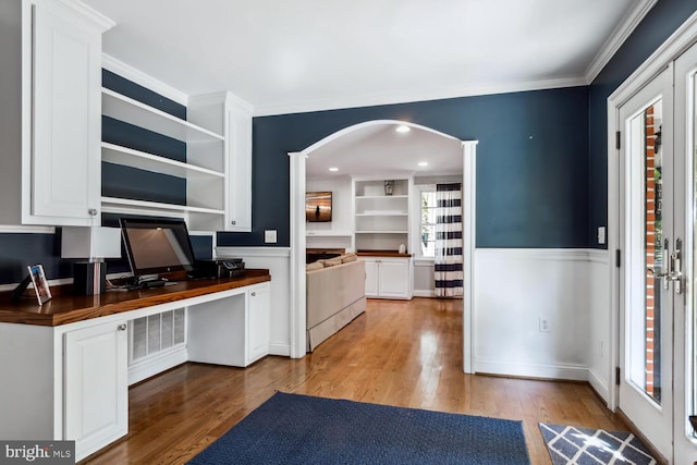 kitchen with light hardwood / wood-style flooring, a healthy amount of sunlight, built in desk, and butcher block countertops