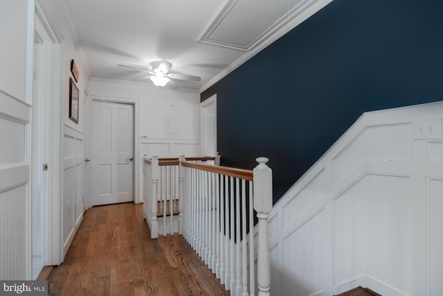 corridor with dark wood-type flooring and crown molding