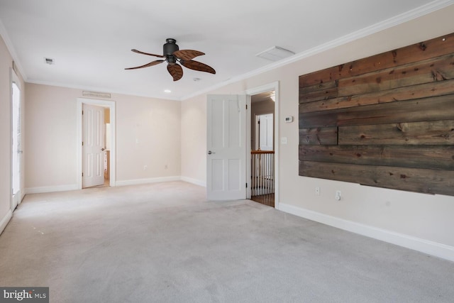 carpeted empty room with a wealth of natural light, ornamental molding, and ceiling fan