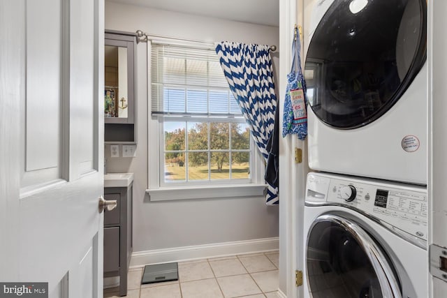 laundry room with stacked washer / dryer and light tile patterned floors