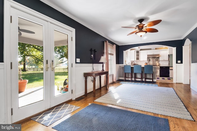 doorway featuring crown molding, hardwood / wood-style flooring, french doors, and ceiling fan