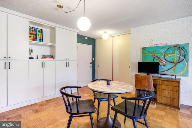 dining room with light parquet floors and a textured ceiling