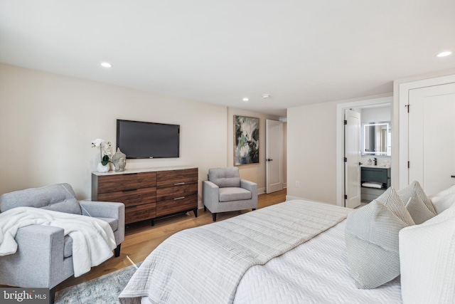 bedroom featuring light wood-type flooring and ensuite bathroom