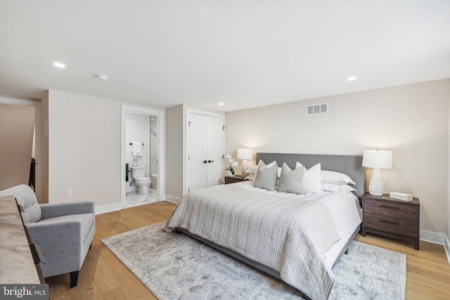 bedroom with light hardwood / wood-style flooring and connected bathroom