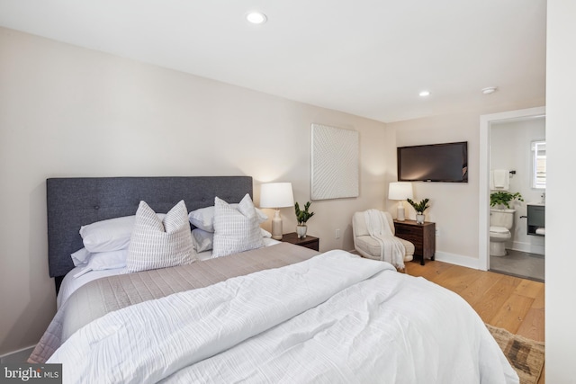 bedroom featuring hardwood / wood-style flooring and ensuite bath