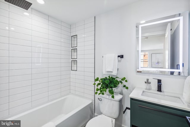 full bathroom with tiled shower / bath, vanity, and toilet