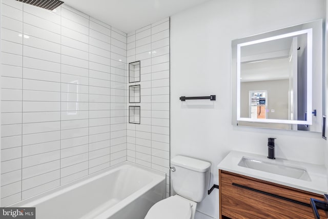 full bathroom featuring tiled shower / bath, vanity, and toilet