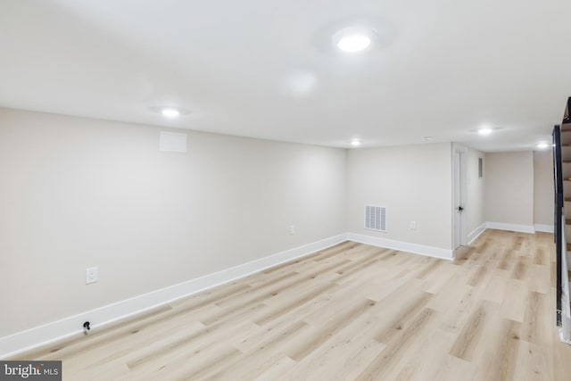 basement with light hardwood / wood-style flooring