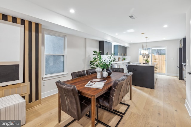 dining room featuring a notable chandelier and light hardwood / wood-style floors