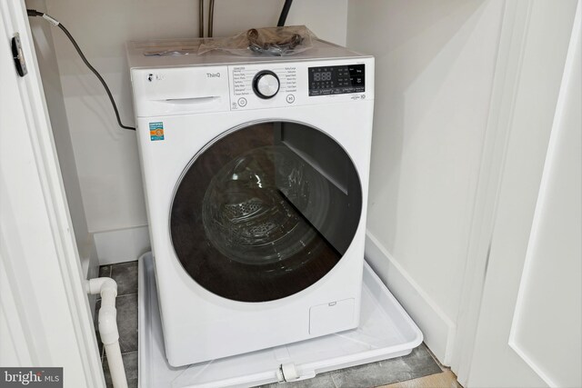 clothes washing area featuring light tile patterned floors and washer / dryer