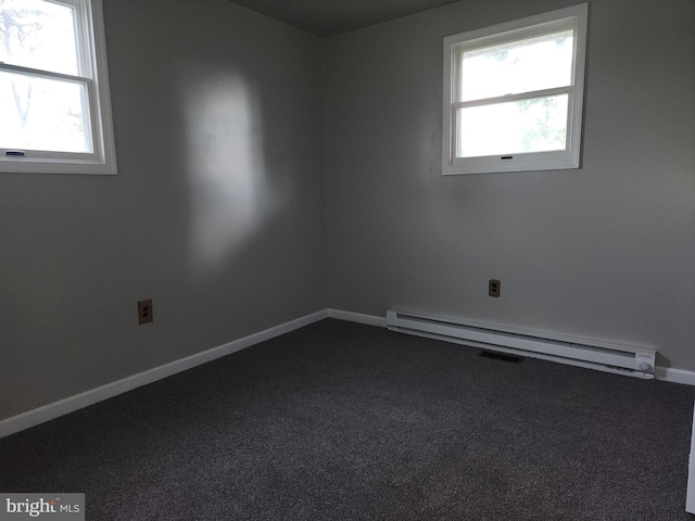 unfurnished room featuring a baseboard heating unit, plenty of natural light, and carpet floors