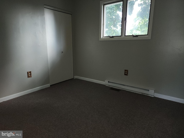 spare room featuring carpet floors and baseboard heating