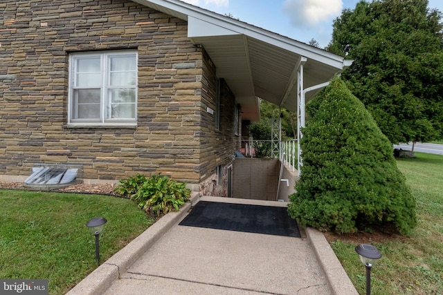 view of exterior entry featuring a yard