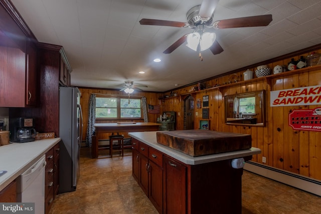 kitchen featuring stainless steel fridge, wood walls, a kitchen island, a baseboard heating unit, and dishwasher