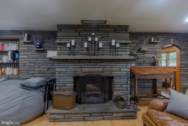 interior details with a stone fireplace and hardwood / wood-style flooring