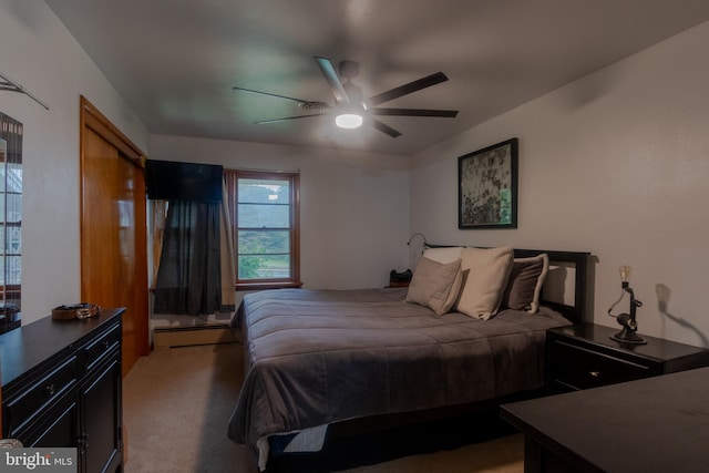 carpeted bedroom featuring ceiling fan and a baseboard radiator