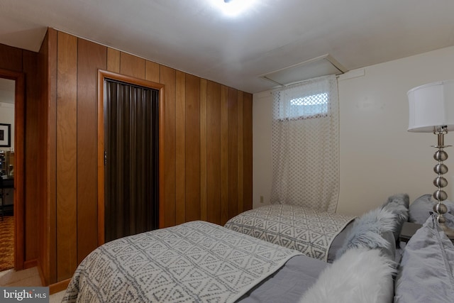 carpeted bedroom featuring wood walls