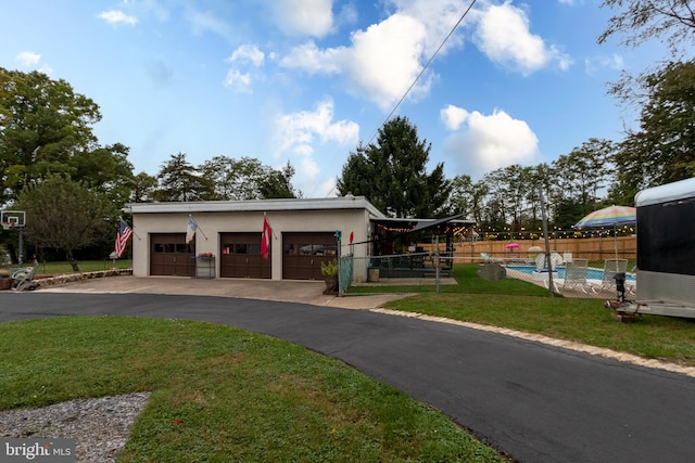 view of front facade with a fenced in pool, a front lawn, and a garage