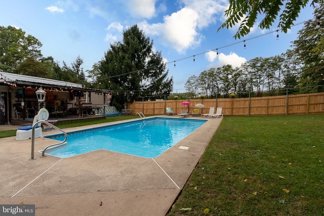 view of pool with a lawn and a patio area