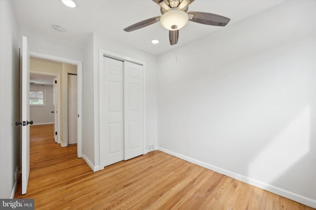 unfurnished bedroom featuring ceiling fan, a closet, and light hardwood / wood-style floors