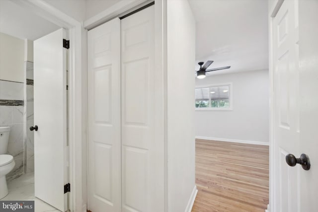 bathroom with baseboards, wood finished floors, toilet, and ceiling fan